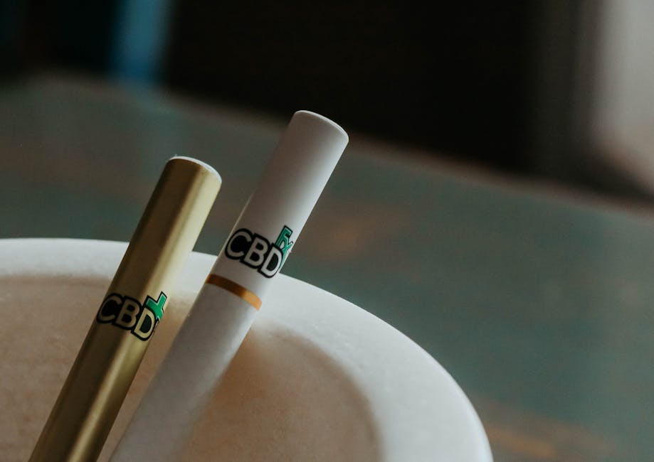 Plan rapproché de stylos à vape CBD disposés dans un cendrier élégant